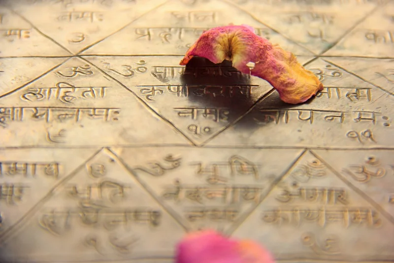 A collection of yantras arranged in a circular pattern, each one representing a different deity or spiritual concept, surrounded by offerings and incense